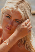 Blonde model wearing Freshwater Peal ring and bangle.