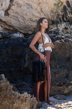 Full body shot of the model holding the Midnight Drift Tassel Leather Bag, wearing Herkimer Diamond rings, bangle, thread earrings, and necklace in gold,.