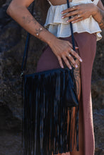 Model holding the Midnight Drift Tassel Leather Bag, paired with Herkimer Diamond rings and bangle, showcasing a chic and sophisticated look.