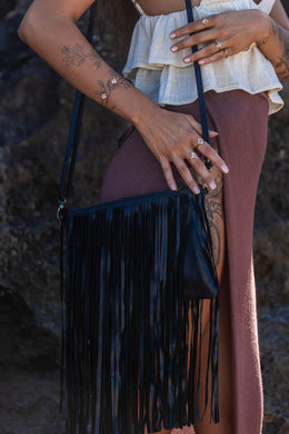 Model holding the Midnight Drift Tassel Leather Bag, paired with Herkimer Diamond rings and bangle, showcasing a chic and sophisticated look.