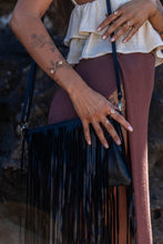 Close-up shot of the Midnight Drift Tassel Leather Bag, with the model wearing Herkimer Diamond rings and bangles in gold, highlighting the elegant accessories.