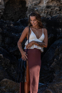 Full-body shot of the Midnight Drift Tassel Leather Bag, with the model wearing Herkimer Diamond rings, necklace, thread earrings and bangles in gold.