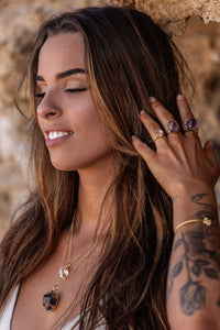 Close-up of the model wearing a gold Higher Realm Herkimer Diamond Crystal Necklace, paired with amethyst rings, an amethyst necklace, Herkimer Diamond rings, and a bangle, highlighting the natural beauty and elegance of the collection.