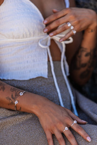 Close-up of the model’s hand wearing Higher Realm Herkimer Diamond rings and bangle in silver, with the diamonds sparkling in the light.