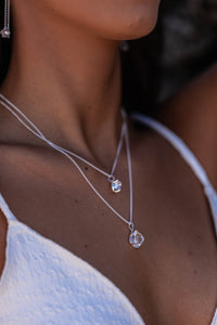 Very close-up of the model’s neck showcasing two intricate small silver Higher Realm Herkimer Diamond Crystal Necklaces, emphasizing the delicate beauty and clarity of the Herkimer diamonds.