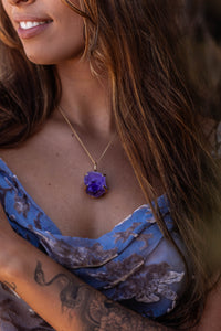 Close-up of model wearing the large Violet Horizon Amethyst Crystal Necklace in gold, showcasing the raw beauty of the hand-dug amethyst against her skin.