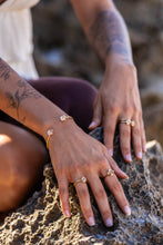 Model’s hands on a lighter rock background showcasing the Higher Realm Herkimer Diamond rings in gold, paired with a matching Herkimer Diamond bangle, emphasising the radiant beauty of the Herkimer diamonds.